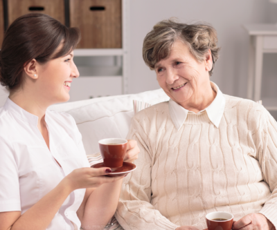 Image of a carer sharing a happy moment with client and having a cup of tea